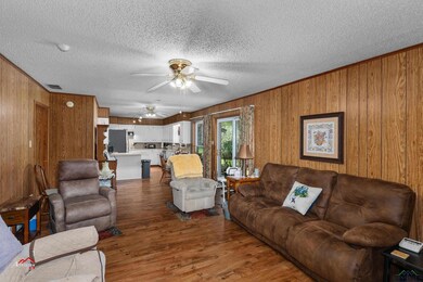 Living room with wood-type flooring, ceiling fan, 