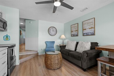 Living room with a textured ceiling, a ceiling fan