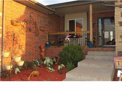 Covered country porch with nice landscaping beds o