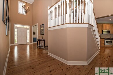 Two story foyer, hardwood flooring, wood stair tre