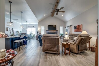 Living room with beam ceiling, ceiling fan, a barn