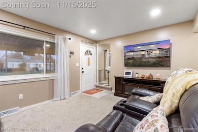 Carpeted living room with baseboards and recessed lighting