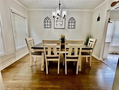 Dining area with wood finished floors, a chandelie