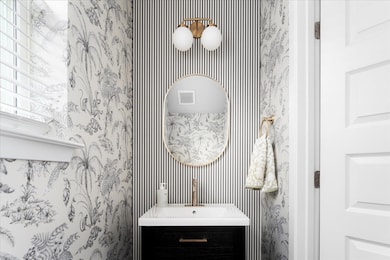 Bathroom featuring vanity and wallpapered walls