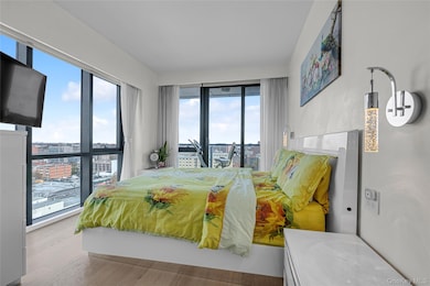 Bedroom with access to outside, a view of city, and wood finished floors