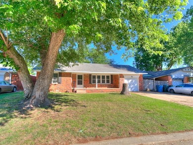 Single story home featuring driveway, a garage, and brick siding