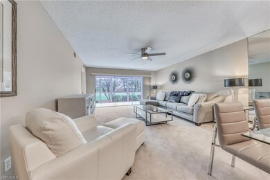 Carpeted living room featuring ceiling fan and a t