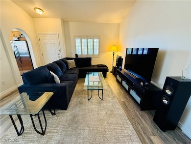 Living area with arched walkways, wood finished fl