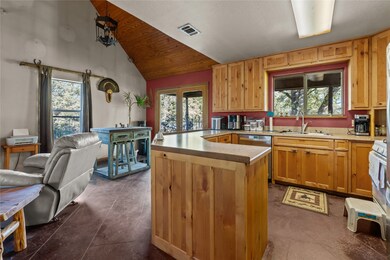 Kitchen featuring light countertops, healthy amount of natural light, open floor plan, high vaulted ceiling, and stainless steel dishwasher
