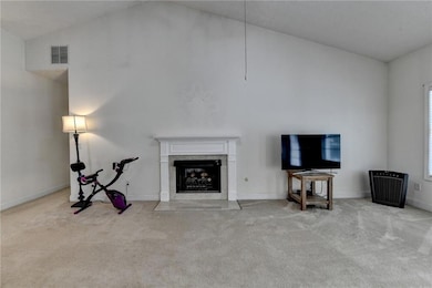 Unfurnished living room featuring carpet, a high end fireplace, high vaulted ceiling, and baseboards