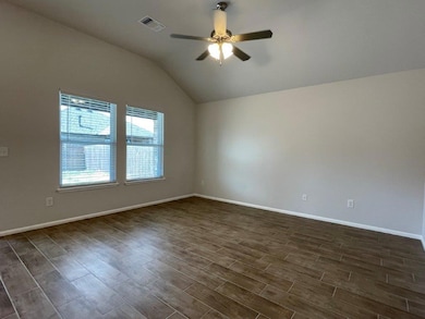 Unfurnished room featuring wood finish floors, vaulted ceiling, and ceiling fan