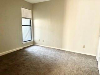 Unfurnished room with dark carpet
