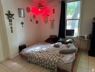 Bedroom with baseboards and light tile patterned floors