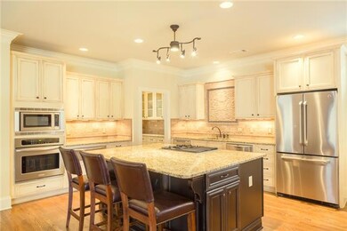 With elegant practicality, the open kitchen boasts of new task and overhead lighting, travertine backsplash and ample workspace.