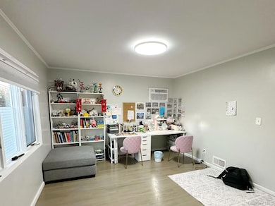Office with crown molding, light wood-type flooring, and an AC wall unit