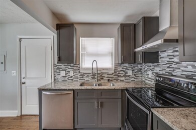 Newly updated tile backsplash and countertops. The door on the left accesses the side yard.