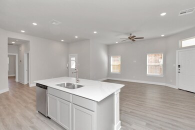 Island kitchen with double sinks and dishwasher.