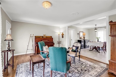 Dining room with wood finished floors, crown molding, and baseboards