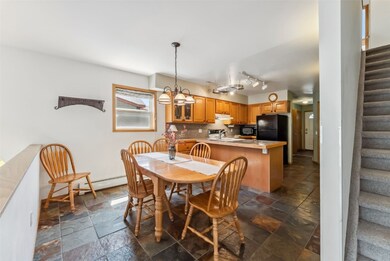 Dining area with stairs, stone tile floors, and a