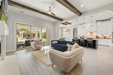 Living room featuring arched walkways, beamed cei