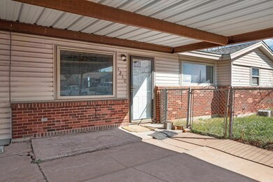 Property entrance with a gate, fence, and brick si