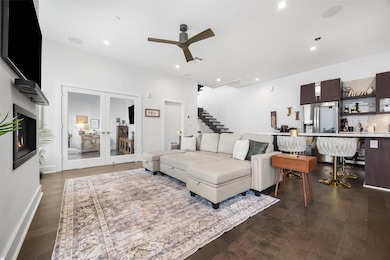 Living room featuring french doors, ceiling fan, a