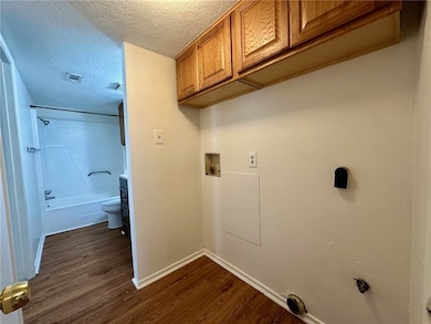 Washroom with cabinet space, washer hookup, dark w