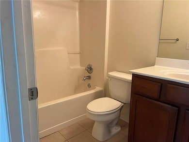 Bathroom with light tile patterned flooring, vanity, and tub / shower combination