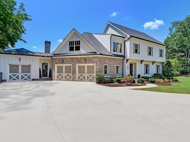 View of front facade featuring driveway and a chimney