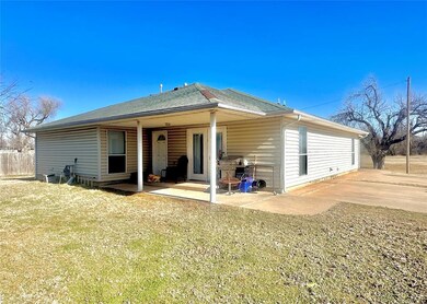 Back of house featuring a lawn and a patio