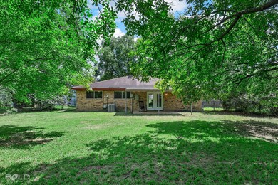 Rear view of house with a patio area, a yard, and 
