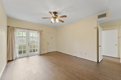 Light-filled living room with French doors opening