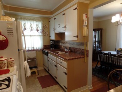 Kitchen sink area with backsplash. Dining room to the right.