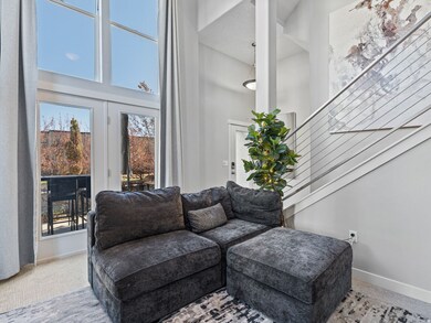 Living area featuring stairway, carpet floors, and a towering ceiling