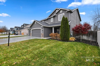 View of front of home featuring concrete driveway, stone siding, and an attached garage