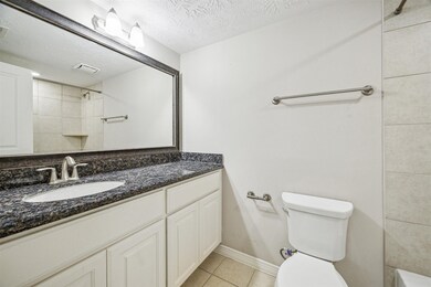 Secondary bathroom with tile floors, sconce lighti