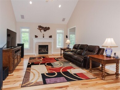 Impressive Great Room with soaring cathedral ceiling, ceiling fan plus attractive gas fireplace.