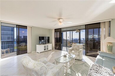 Tiled living room with ceiling fan and a wall of w