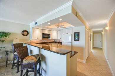 Kitchen featuring white fridge, dark stone counter