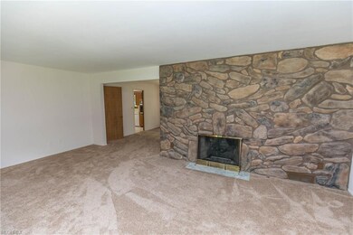 Living room with stone wall woodburning/gas log fi