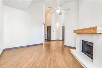 Unfurnished living room with ceiling fan, high vau