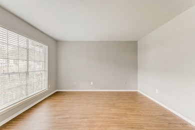 Empty room with light wood-style flooring and baseboards