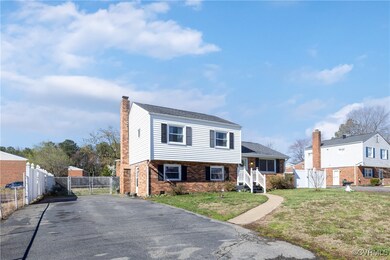 Tri-level home featuring a chimney, fence, a front