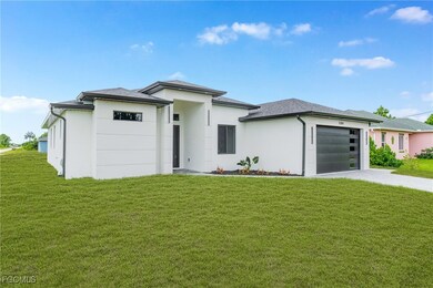 Prairie-style home featuring an attached garage, driveway, a front yard, and stucco siding