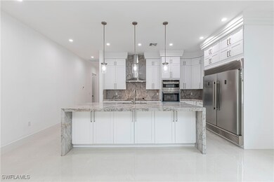 Kitchen with white cabinets, wall chimney exhaust