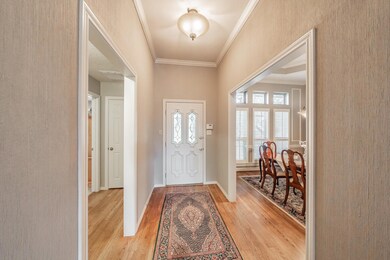 Foyer entrance featuring light hardwood / wood-style floors and crown molding