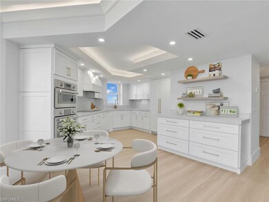 Kitchen with a sink, light wood-style flooring, white cabinetry, light countertops, and recessed lighting