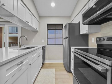 Kitchen featuring stainless steel appliances, white cabinets, light stone countertops, light wood-type flooring, and recessed lighting