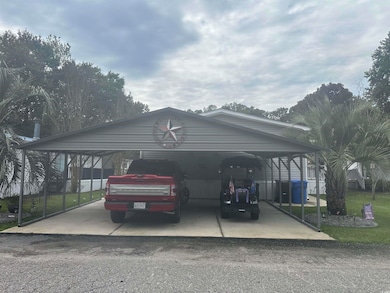 View of vehicle parking featuring a carport and driveway