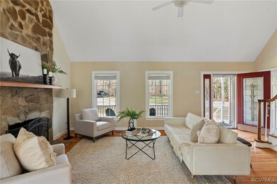 Living room featuring ceiling fan, high vaulted ceiling, a stone fireplace, and light hardwood / wood-style floors